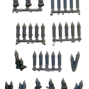 May include: A collection of gray plastic miniature candles on sprues. The candles vary in size and arrangement, with some grouped together and others in rows. The image is taken against a white background.