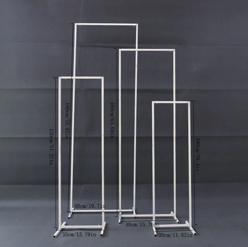 May include: White metal wedding arch set. The tallest arch is 180cm (70.92 in) tall, and the shortest is 100cm (39.4 in) tall. The arches are rectangular and stand on square bases. The set includes four arches of varying heights and widths.