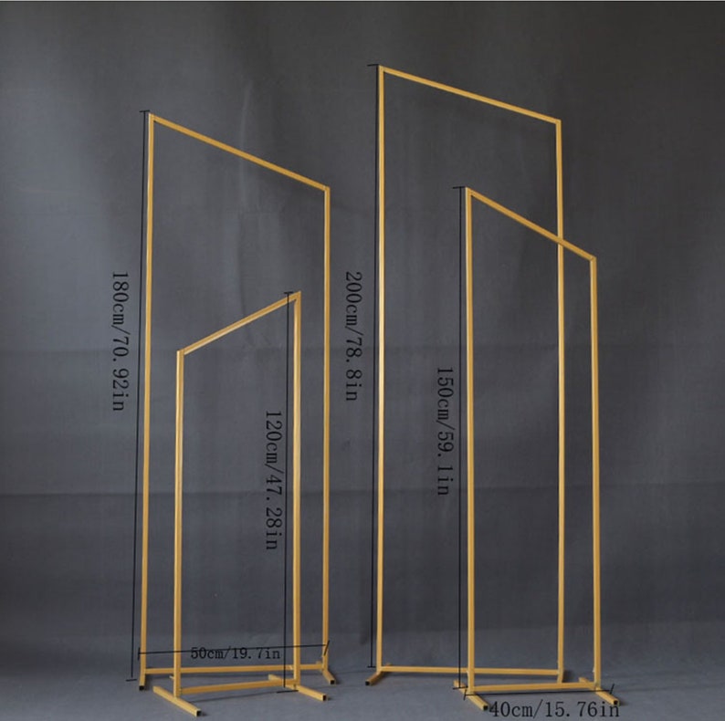 May include: Four gold metal arch stands of varying heights. The tallest is 200 cm high, and the shortest is 120 cm high. The stands are rectangular with a square base, suitable for weddings or events.