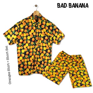 May include: A black and orange short-sleeved button-up shirt and matching shorts with a repeating pattern of oranges and leaves. The text "BAD BANANA" is printed in white on a black background above the shirt. The text "Oranges Shirt + Short Set" is printed vertically on the left side of the image.