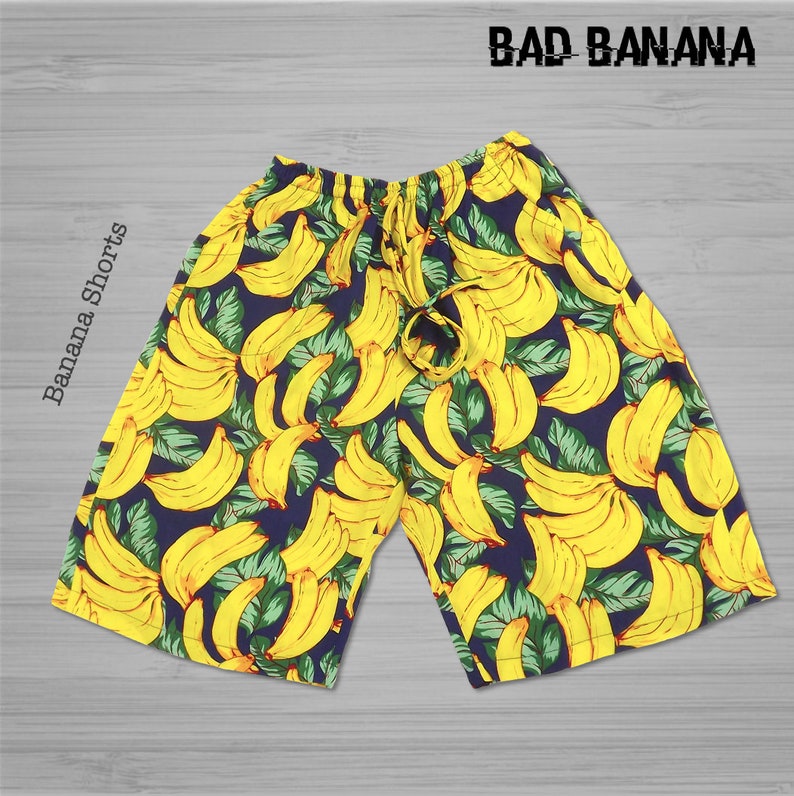Pu&ograve; includere: Shorts blu con stampa di banane gialle. I pantaloncini hanno una vita con coulisse e il testo "BAD BANANA" &egrave; stampato in alto.