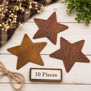 May include: Three five-pointed stars with a textured, rusted brown finish. A small rectangular sign with a white background and a dark brown border displays the black text 10 Pieces. The stars have a weathered appearance with dark brown spots.