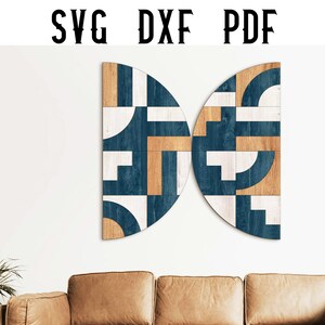 Pode incluir: Arte de parede geométrica em um design semicircular. A obra de arte apresenta um padrão de formas azuis, brancas e douradas. O texto "SVG DXF PDF" está no topo. A arte é montada em uma parede branca acima de um sofá de couro marrom.