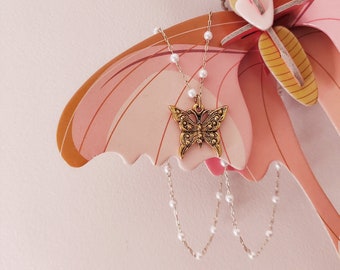 Collier perlé avec pendentif papillon de style vintage, antique. Fermoir en aile d'ange