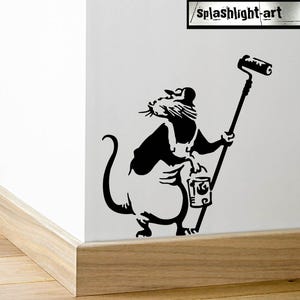 May include: Black and white stencil art of a rat wearing overalls and a painter's hat, holding a paint roller and a paint can. The rat is depicted as a painter. The text "splashlight-art" is in the upper right corner.