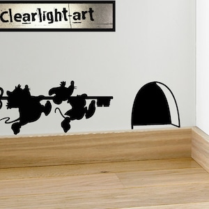Può includere: Arte murale a silhouette nera raffigurante tre topi che trasportano una chiave verso una tana. Il testo "clearlight-art" è sopra i topi. L'arte è montata su una parete bianca con uno zoccolo in legno.