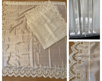May include: White sheer curtains with a delicate lace trim. The curtains are made of a lightweight fabric and have a scalloped edge.