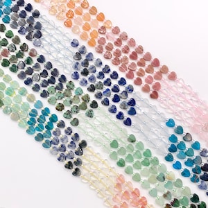 May include: A collection of heart-shaped gemstone beads in various colors, including shades of blue, green, pink, and orange. The beads are strung together, creating a visually appealing display of jewelry components.