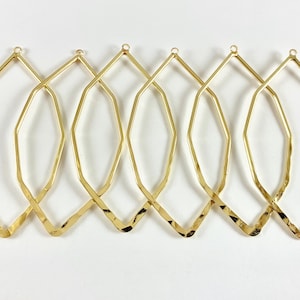 May include: Six gold-toned metal hoops with a geometric, faceted design. The hoops are all the same size and shape, and they are arranged in a row.