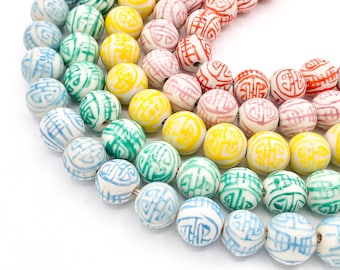 May include: A strand of white ceramic beads with colorful Chinese characters. The beads are arranged in a rainbow pattern, with red, orange, yellow, green, blue, and purple beads.