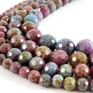 May include: A strand of faceted gemstone beads in shades of pink, blue, and green. The beads are round and have a slightly irregular shape.