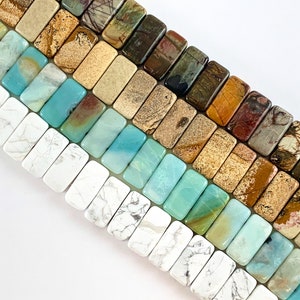 May include: Close-up of a collection of rectangular gemstone beads in various colors. The beads include white, turquoise, brown, and tan hues. These beads are ideal for jewelry making, such as bracelets and necklaces.
