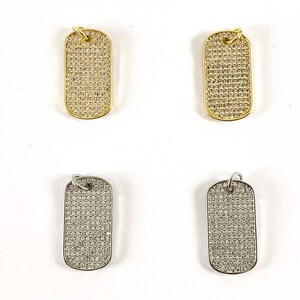 May include: Four dog tag pendants, two gold and two silver, with a pave diamond design.