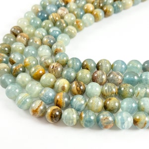 May include: A strand of round, blue and brown agate beads. The beads have a marbled pattern and are approximately 10mm in diameter.
