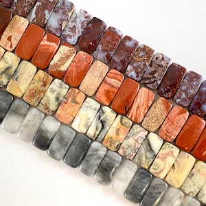 May include: A strand of colorful, rectangular, agate gemstone beads. The beads are in shades of red, orange, yellow, and gray.