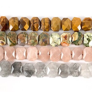 May include: Four rows of faceted gemstone beads. The top row is tiger's eye, the second row is green and brown jasper, the third row is pink, and the bottom row is gray.