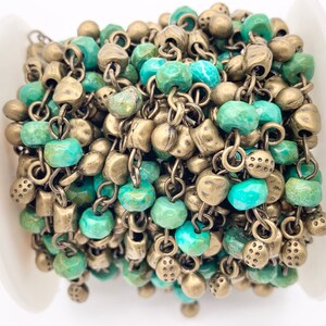 May include: A spool of turquoise and brass chain, featuring alternating turquoise beads and brass chain links. The chain is perfect for jewelry making or adding a unique touch to any craft project.