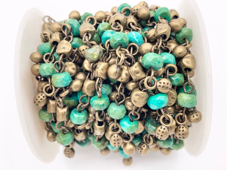 May include: A spool of turquoise and brass chain, featuring alternating turquoise beads and brass chain links. The chain is perfect for jewelry making or adding a unique touch to any craft project.