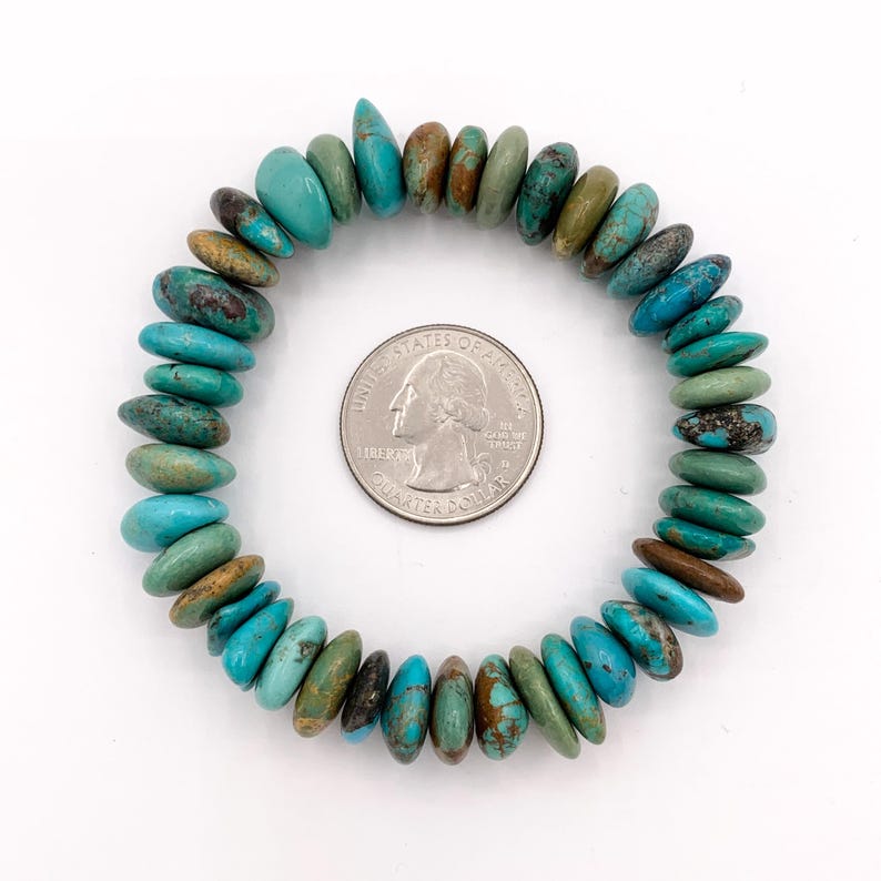 May include: A turquoise stone bracelet with a variety of blue-green hues. The bracelet is circular and made of polished, irregular-shaped stones. A US quarter is next to the bracelet for size reference.