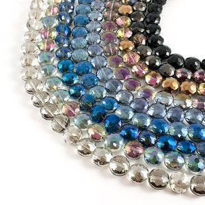 May include: A strand of iridescent glass beads in various shades of blue, gray, and clear. The beads are oval-shaped and have a faceted design.