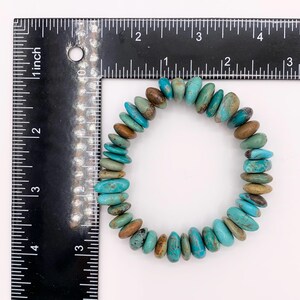 May include: A turquoise bracelet featuring a mix of blue, green, and brown stones. The bracelet is approximately 5 cm in diameter. The oval-shaped stones are strung together in a circular design.