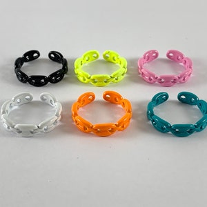 May include: Six colorful chain link rings in black, yellow, pink, orange, and teal.