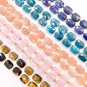 May include: Close-up of several strands of gemstone beads in various colors, including pink, blue, and brown. The beads are rectangular and strung on gold-colored wire, creating a visually appealing pattern. The gemstones appear to be polished and faceted.