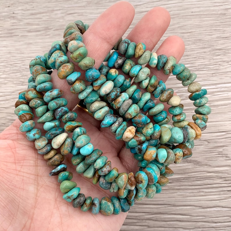 Pu&ograve; includere: Fili di perline di pietre preziose turchesi in varie tonalit&agrave; di blu, verde e marrone. Le perline hanno una forma irregolare e sono infilate insieme. Ideale per la creazione di gioielli.