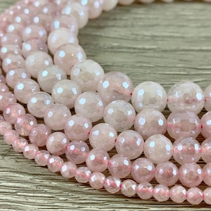May include: A close-up of several strands of pink rose quartz beads. The beads are faceted and have a translucent appearance.