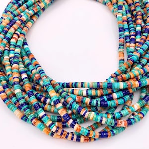 May include: A multi-strand necklace featuring small, flat beads in shades of turquoise, orange, white, and navy blue. The beads are strung together, creating a layered effect. The necklace is displayed against a white background.
