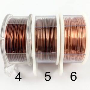May include: Three spools of copper wire in clear plastic containers. The wire is a warm copper color. The spools are labeled 4, 5, and 6.