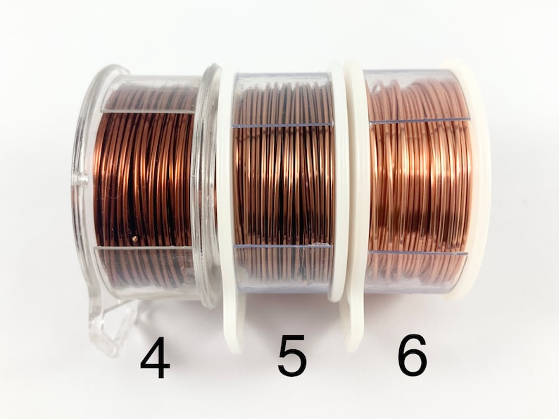 May include: Three spools of copper wire in clear plastic containers. The wire is a warm copper color. The spools are labeled 4, 5, and 6.
