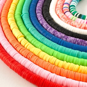 May include: A rainbow assortment of colorful round polymer clay beads. The beads are stacked in rows, creating a vibrant and colorful display.