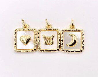 May include: Three gold-toned pendant charms with white mother-of-pearl inlays. Each charm features a different design: a heart, a butterfly, and a crescent moon.