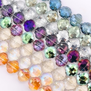 May include: A strand of faceted glass beads in various colors, including clear, purple, green, blue, and orange. The beads are shaped like small flowers with a faceted design.