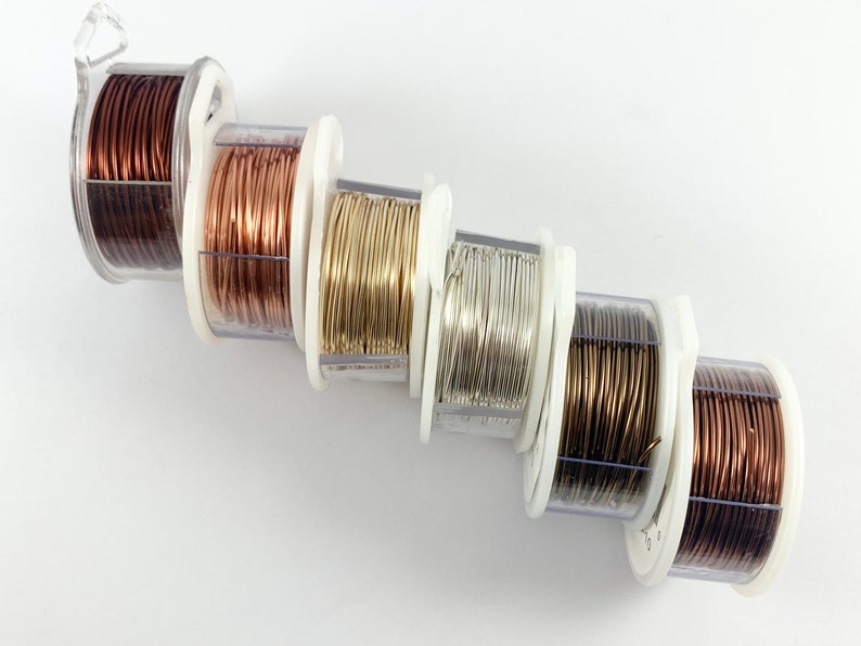 May include: Five spools of wire in different colors: copper, rose gold, gold, silver, and bronze. The spools are arranged in a diagonal line.
