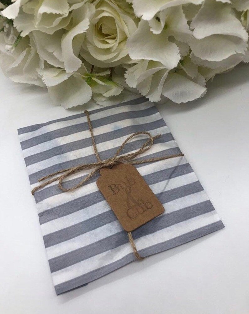 May include: A grey and white striped tissue paper gift bag with a brown tag that says "Bub & Cub". The bag is tied with twine.