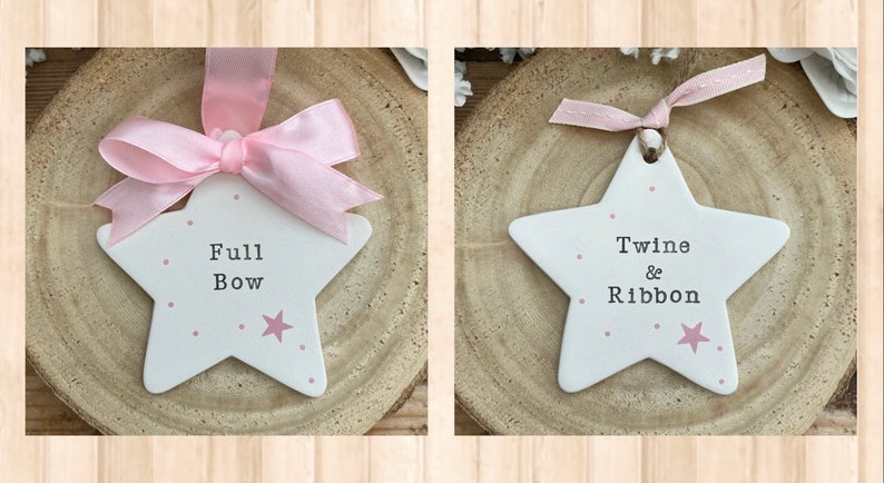 May include: Two white ceramic star ornaments with pink polka dots and a pink star. One ornament says "Full Bow" and the other says "Twine & Ribbon".