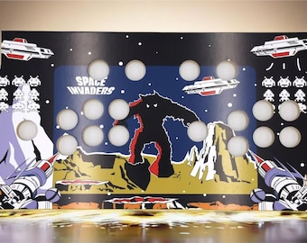 May include: A black and blue arcade cabinet control panel with a Space Invaders theme. The panel features a large alien monster, two spaceships, and the text "Space Invaders".