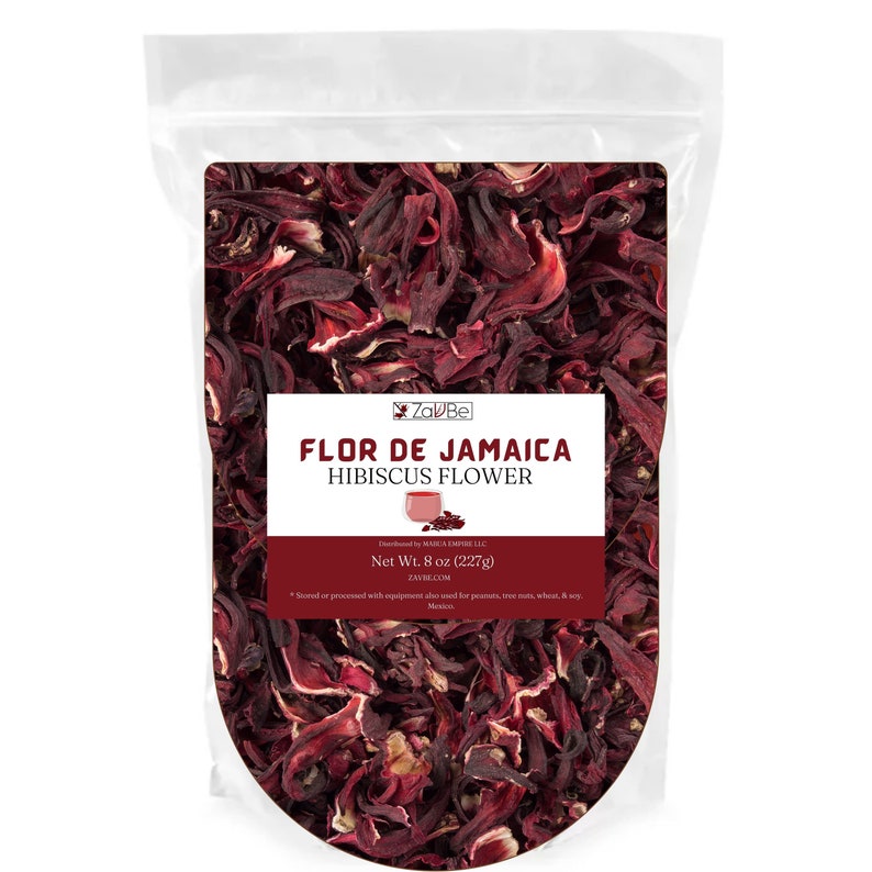 May include: A transparent bag containing dried hibiscus flowers. The label reads "FLOR DE JAMAICA HIBISCUS FLOWER" and the net weight is 227g. The flowers are a deep red hue, filling the bag. The product is from Za'Bel.