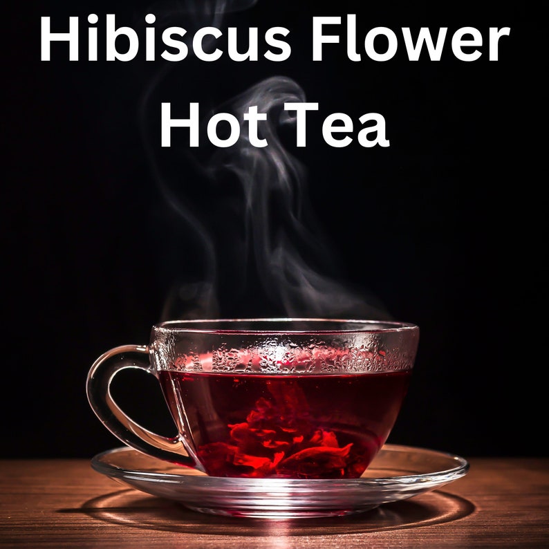 May include: A glass teacup and saucer filled with red hibiscus flower tea. Steam rises from the cup against a dark backdrop. The text "Hibiscus Flower Hot Tea" is displayed above the cup.