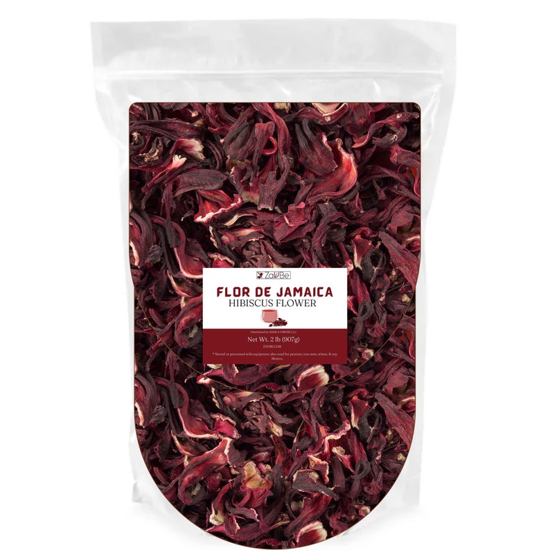 May include: A transparent bag containing dried hibiscus flowers. The label states "FLOR DE JAMAICA HIBISCUS FLOWER" and "Net Wt. 2 lb (900g)". The flowers are a rich red hue.