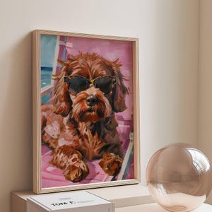 May include: A painting of a brown dog wearing sunglasses, sitting on a pink and white striped beach chair. The dog is looking directly at the viewer.