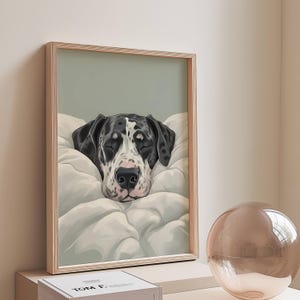 Könnte beinhalten: Gerahmter Kunstdruck mit einem schwarz-weiß gefleckten Great Dane, der auf einem weißen Kissen schläft. Die Augen des Hundes sind geschlossen, und das Kunstwerk hat eine weiche, neutrale Farbpalette. Der Rahmen ist hellholzfarben.