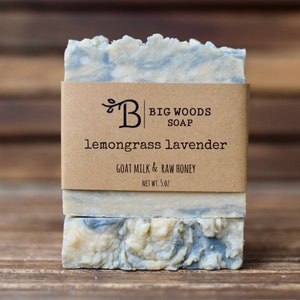 May include: A bar of lemongrass lavender soap with a brown paper label that reads "Big Woods Soap", "lemongrass lavender", "Goat Milk & Raw Honey", and "Net Wt. 5 oz".