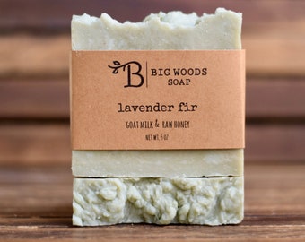 May include: A bar of green soap with a brown label that reads "B BIG WOODS SOAP lavender fir GOAT MILK & RAW HONEY NET WT. 5 OZ"
