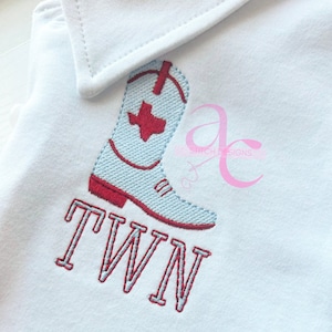 May include: Embroidered design of a blue and red cowboy boot with a red Texas star on the boot shaft. The word "TWN" is embroidered below the boot in red and blue thread.