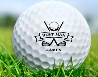 May include: A white golf ball with a black design featuring crossed golf clubs, a golf ball, and the text "BEST MAN JAMES".