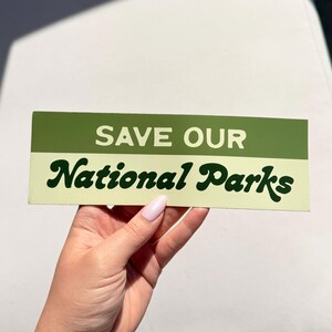 Green and beige bumper sticker that reads, Save Our National Parks