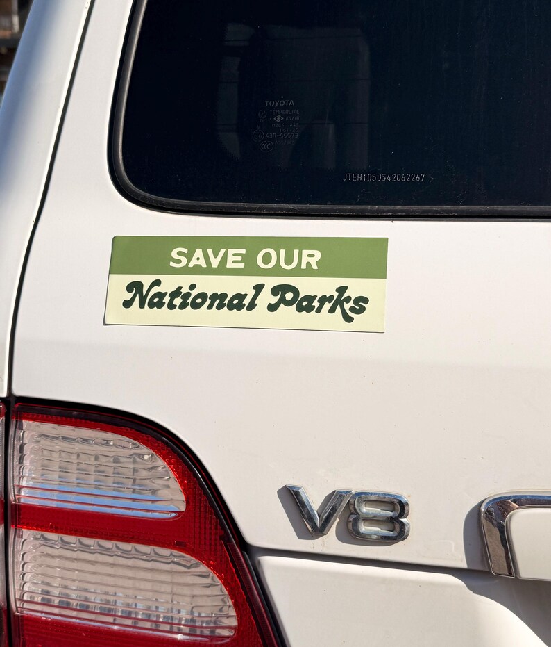 Green and beige bumper sticker that reads, Save Our National Parks